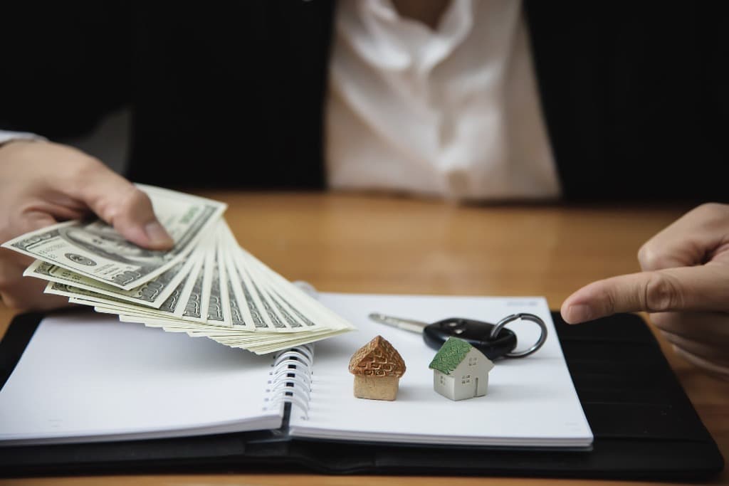 Modellhaus und Schlüssel auf Finanzierungsunterlagen — Baufinanzierung